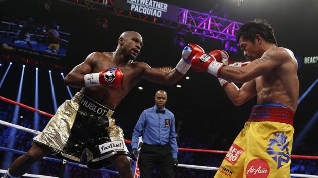 (FILES) In this file photo taken on May 02, 2015 Floyd Mayweather Jr. exchange punches with Manny Pacquiao(AFP)