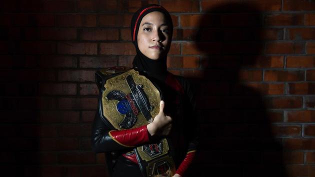 Diana poses for a picture with the Wrestlecon championship belt. “As soon as she became popular, we received a lot of messages from fellow hijabis who inquired about joining wrestling as well. She kind of broke the barrier and just proved to them that if she can do it, they can do it too,” said Ayez Shaukat Fonseka, her coach and fellow fighter. (Mohd Rasfan / AFP) Diana poses for a picture with the Wrestlecon championship belt. “As soon as she became popular, we received a lot of messages from fellow hijabis who inquired about joining wrestling as well. She kind of broke the barrier and just proved to them that if she can do it, they can do it too,” said Ayez Shaukat Fonseka, her coach and fellow fighter. (Mohd Rasfan / AFP)