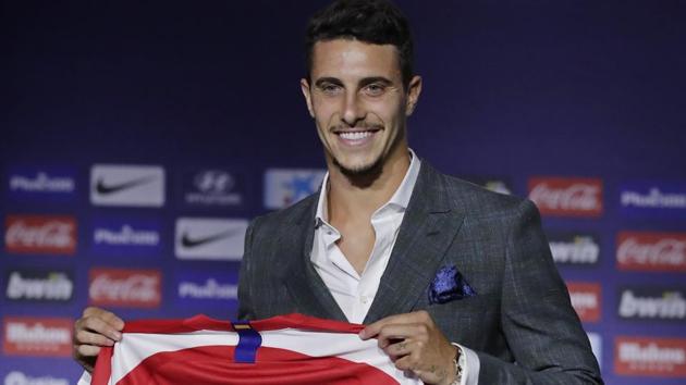 Mario Hermoso holds up his new shirt after signing for Atletico Madrid from Espanyol.(AP)