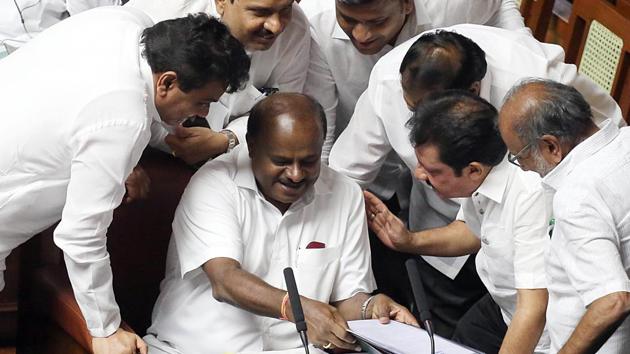Chief Minister of Karnataka HD Kumaraswamy in conversation with other members during the trust motion debate at Vidhana Soudha in Bengaluru on Thursday.(ANI photo)