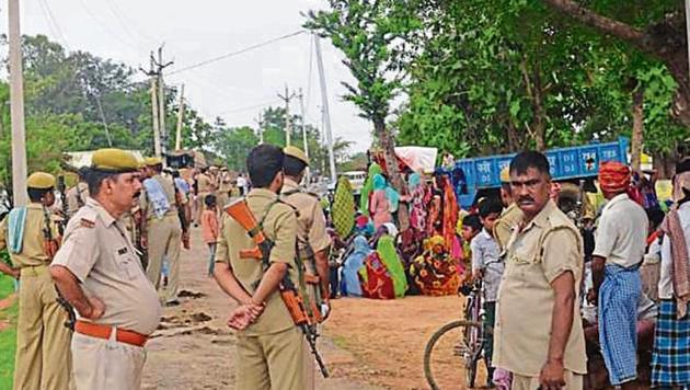 Policemen standing guard at Umbha village in Sonbhadra district, July 18, 2019, after 10 people were killed in a land dispute the previous day.(HT Photo)