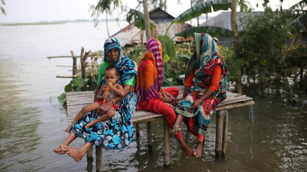Bangladeshi people sit atop a bamboo platform as they look at flood waters in Kurigram district, in the northern part of Bangladesh. Survivors scrambled for higher ground as torrential monsoon rains swept away homes and triggered landslides across South Asia on July 16, with millions of people affected and at least 180 dead. (Rehman Asad / AFP) Bangladeshi people sit atop a bamboo platform as they look at flood waters in Kurigram district, in the northern part of Bangladesh. Survivors scrambled for higher ground as torrential monsoon rains swept away homes and triggered landslides across South Asia on July 16, with millions of people affected and at least 180 dead. (Rehman Asad / AFP)