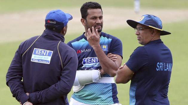 Sri Lanka's captain Dimuth Karunaratne, center, interacts with team coach Chandika Hathurusingha(R).(AP)