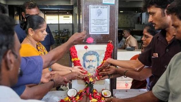 Employees pay tribute in front of a portrait of P. Rajagopal, founder of Saravana Bhawan(REUTERS)