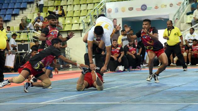 Baladhyay Baramati (white) and Shivneri Junnar (red) in action during the fourth edition of Pune League Kabaddi at Shiv Chhatrapati sports complex boxing hall in Balewadi on Thursday.(HT)
