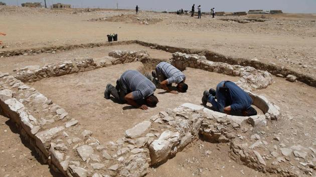 Muslim workers of Israel’s antiquities authority pray at the newly discovered remains of an ancient rural mosque, dating back to the era between the 7th and the 8th centuries, in the Israeli Bedouin town of Rahat in the Negev desert. The remains of this rare historic building were discovered during preparations for building a new neighborhood. (Menahem Kahana / AFP) Muslim workers of Israel’s antiquities authority pray at the newly discovered remains of an ancient rural mosque, dating back to the era between the 7th and the 8th centuries, in the Israeli Bedouin town of Rahat in the Negev desert. The remains of this rare historic building were discovered during preparations for building a new neighborhood. (Menahem Kahana / AFP)