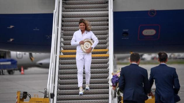 2019 Wimbledon Women’s singles champion, tennis player Simona Halep, descends from the airplane with her trophy as she arrives back home at the Henry Coanda International Airport in Bucharest, Romania. (Daniel Mihailescu / AFP) 2019 Wimbledon Women’s singles champion, tennis player Simona Halep, descends from the airplane with her trophy as she arrives back home at the Henry Coanda International Airport in Bucharest, Romania. (Daniel Mihailescu / AFP)