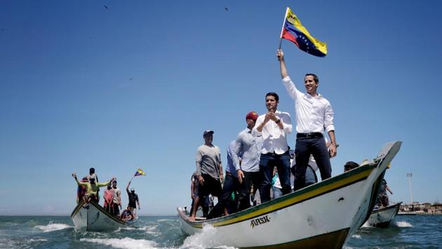 Venezuelan opposition leader Juan Guaido waves a national flag as he arrives in a boat for a meeting with supporters near Porlamar, Isla de Margarita, Venezuela. (Leo Alvarez / Prensa Juan Guaido via REUTERS) Venezuelan opposition leader Juan Guaido waves a national flag as he arrives in a boat for a meeting with supporters near Porlamar, Isla de Margarita, Venezuela. (Leo Alvarez / Prensa Juan Guaido via REUTERS)