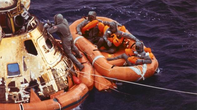 Para rescue-man Lt. Clancy Hatleberg closes the Apollo 11 spacecraft hatch as astronauts Neil Armstrong, Michael Collins, and Buzz Aldrin, Jr., await a helicopter pickup from their life raft. They splashed down at 12:50 pm EDT July 24, 1969, 900 miles southwest of Hawaii after a successful lunar landing mission. (NASA) Para rescue-man Lt. Clancy Hatleberg closes the Apollo 11 spacecraft hatch as astronauts Neil Armstrong, Michael Collins, and Buzz Aldrin, Jr., await a helicopter pickup from their life raft. They splashed down at 12:50 pm EDT July 24, 1969, 900 miles southwest of Hawaii after a successful lunar landing mission. (NASA)