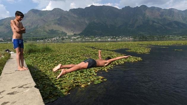 A boy dives into the Dal Lake while another looks on during a hot day, in Srinagar, Jammu and Kashmir. (Waseem Andrabi / HT Photo ) 