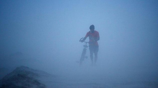 A man pushes his bike during a dust storm at the Sangam, the confluence of the rivers Ganges, Yamuna and mythical Saraswati, in Allahabad, Uttar Pradesh. (Sanjay Kanojia / AFP) 