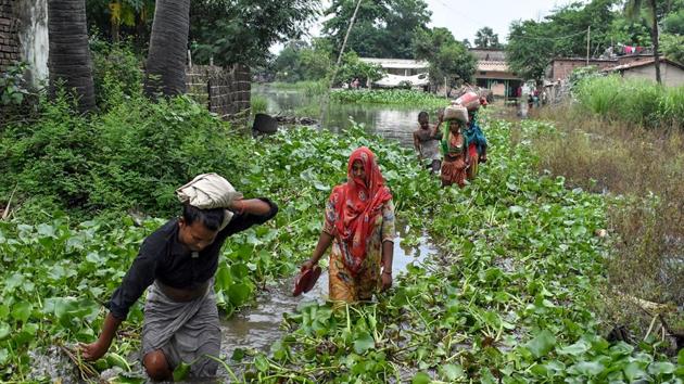 Residents carrying their belongings make their way through aquatic plants among floodwaters after heavy monsoon rains at Jaynagar village in Sitamarhi district in the Indian eastern state of Bihar on July 20, 2019. (Photo by STR / AFP) (AFP) Residents carrying their belongings make their way through aquatic plants among floodwaters after heavy monsoon rains at Jaynagar village in Sitamarhi district in the Indian eastern state of Bihar on July 20, 2019. (Photo by STR / AFP) (AFP)