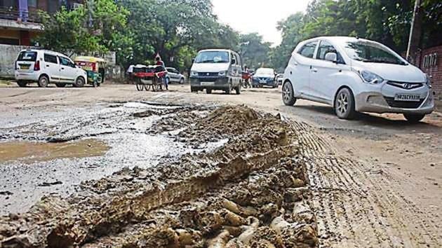 A roughly 1-km-long, 30-metre-wide dividing road between sectors 1 and 2 in Palam Vihar has foot-deep potholes. (Yogendra Kumar/HT)