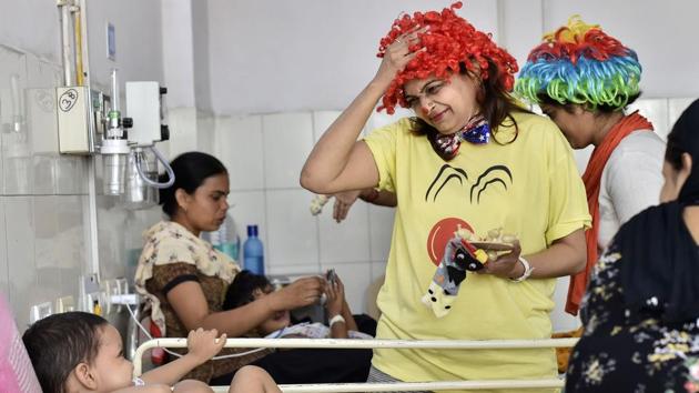 On a recent Saturday, the Clownselors were at the cancer ward of the Chacha Nehru Bal Chikitsalaya. As they danced, made faces, fell over each other and performed various other antics, 14-month-old Shivam Pandey’s big round eyes followed one clown with a red nose, pink wig and a sock puppet in her hand. (Ravi Choudhary / PTI) 