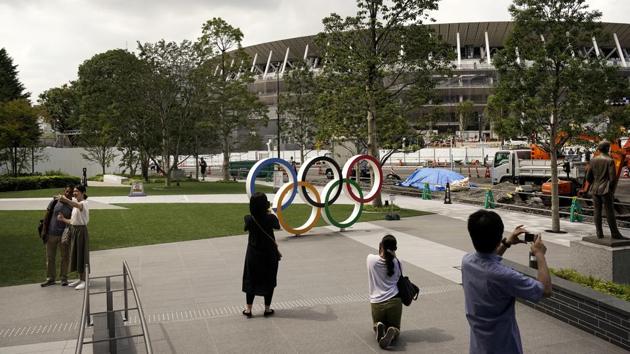 People take pictures of the Olympics Rings displayed near the New National Stadium, a venue for opening and closing ceremonies at the Tokyo 2020 Olympics. Fans, sponsors and politicians celebrated the day around the Japanese capital, displaying placards and clocks showing 365 days to go until the opening ceremony on July 24, 2020. (Jae C. Hong / AP) People take pictures of the Olympics Rings displayed near the New National Stadium, a venue for opening and closing ceremonies at the Tokyo 2020 Olympics. Fans, sponsors and politicians celebrated the day around the Japanese capital, displaying placards and clocks showing 365 days to go until the opening ceremony on July 24, 2020. (Jae C. Hong / AP)