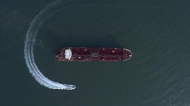 An aerial view shows a speedboat of Iran's Revolutionary Guard moving around the British-flagged oil tanker Stena Impero which was seized in the Strait of Hormuz on Friday by the Guard, in the Iranian port of Bandar Abbas. Global stock markets were subdued Monday while the price of oil climbed as tensions in the Persian Gulf escalated after Iran's seizure of a British oil tanker on Friday.(AP)