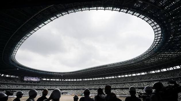 The media tours the new National Stadium in Tokyo. Despite scandals, rising costs and doubts about the economic payoff, the Tokyo Olympics will be a must-see event, if one can find a ticket or a hotel room. (Jae C. Hong / AP)