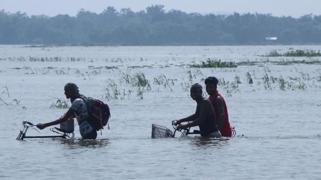 Children have been swept away by floodwaters and others killed in landslides caused by heavy monsoon rains in Assam. In a recent incident, three people have gone missing after they fell into Tawkak river in Charaideo, Assam.(AFP)