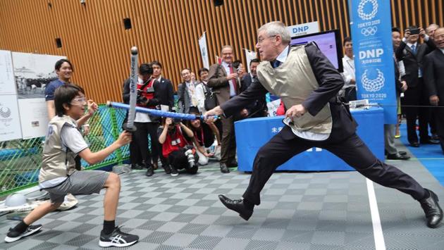 International Olympic Committee (IOC) President Thomas Bach (R) tries mock fencing with Japanese junior high school student Yui Hashimoto during the ‘1 Year to Go’ ceremony. On July 23 Tokyo entered the final leg of its marathon Olympic preparations, marking a year until the 2020 Games open with officials promising a high-tech but eco-friendly event. (Koji Sasahara / AFP) International Olympic Committee (IOC) President Thomas Bach (R) tries mock fencing with Japanese junior high school student Yui Hashimoto during the ‘1 Year to Go’ ceremony. On July 23 Tokyo entered the final leg of its marathon Olympic preparations, marking a year until the 2020 Games open with officials promising a high-tech but eco-friendly event. (Koji Sasahara / AFP)