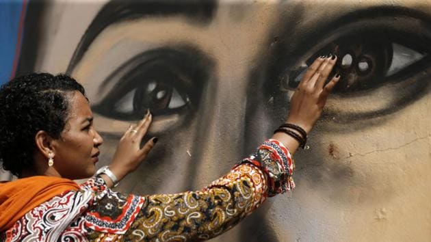 Sudanese activist Eythar Gubara, in front of a mural painting of Mohamed Mattar, on the wall of a youth club in Bahri. The colourful graffiti is part of a campaign to draw faces of protesters killed on June 3 and during the months-long protest movement against now ousted leader Omar al-Bashir on the walls of their family homes. (Ashraf Shazly / AFP)