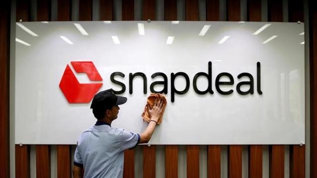 An employee cleans a Snapdeal logo at its headquarters in Gurugram.(Reuters Photo)