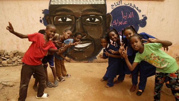 Children gesture in front of a mural painting of a protester killed during the protest. Diab, who lives in the Qatari capital with her family but often returns to her homeland, said painting each mural costs her about $635. “But martyrs took to the streets and died for us. This is the least we can do for them,” she said, who has drawn about 30 portraits of protesters killed in Khartoum. (Ashraf Shazly / AFP)