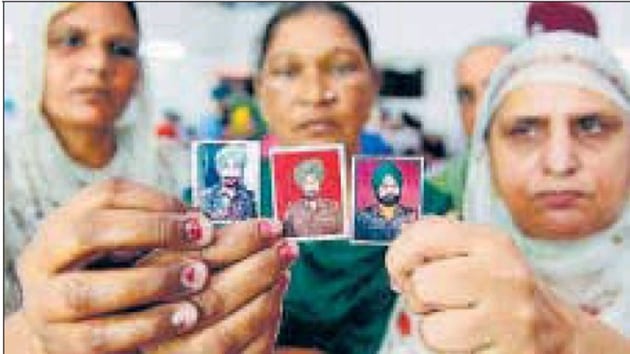 (From left) Wives of slain soldiers Kuldeep Singh, Prem Singh (C), Karnal Singh hold their husbands’ photos before paying homage at a war memorial, on the outskirts of Amritsar on Friday. (From left) Wives of slain soldiers Kuldeep Singh, Prem Singh (C), Karnal Singh hold their husbands’ photos before paying homage at a war memorial, on the outskirts of Amritsar on Friday.