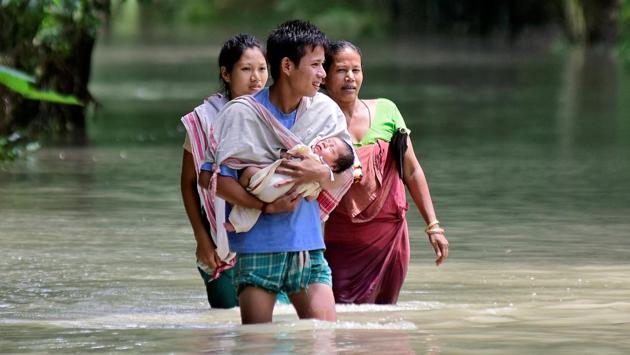 A man carries his new born baby as he and his family members wade through a flooded area to reach a relief camp at a village in Barpeta district Assam. (Anuwar Hazarika / REUTERS) A man carries his new born baby as he and his family members wade through a flooded area to reach a relief camp at a village in Barpeta district Assam. (Anuwar Hazarika / REUTERS)