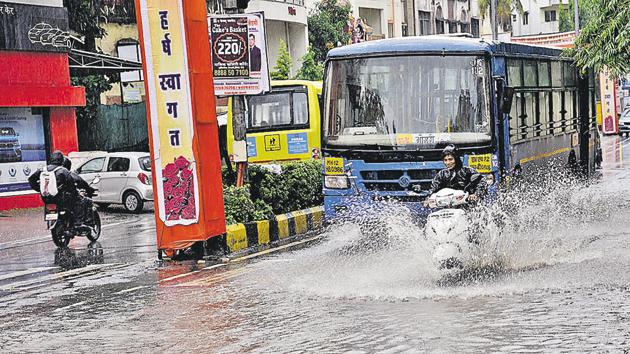 Commuters making their way through waterlogged road near Darshan Mall Chinchwad.(HT/PHOTO)