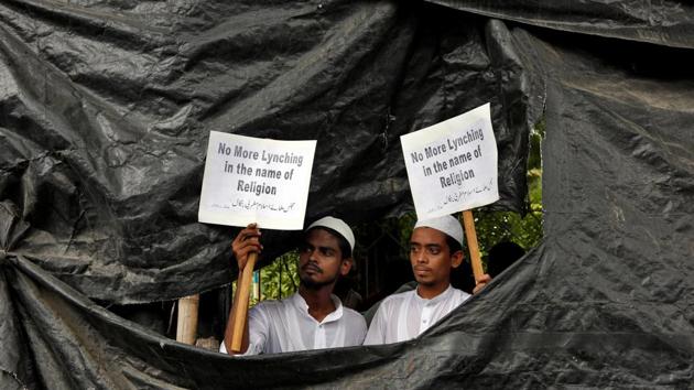 People display placards as they take cover from the rain during a protest organised by Majlis-e-Ulama-e-Islam West Bengal against the recent mob lynching, in Kolkata, West Bengal. (Rupak De Chowdhuri / REUTERS) People display placards as they take cover from the rain during a protest organised by Majlis-e-Ulama-e-Islam West Bengal against the recent mob lynching, in Kolkata, West Bengal. (Rupak De Chowdhuri / REUTERS)