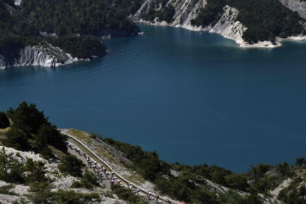 The pack rides past the Lac of Serre-Poncon (Serre-Poncon lake) during the eighteenth stage of the 106th edition of the Tour de France cycling race between Embrun and Valloire, in Valloire. (Jeff Pachoud / AFP) The pack rides past the Lac of Serre-Poncon (Serre-Poncon lake) during the eighteenth stage of the 106th edition of the Tour de France cycling race between Embrun and Valloire, in Valloire. (Jeff Pachoud / AFP)