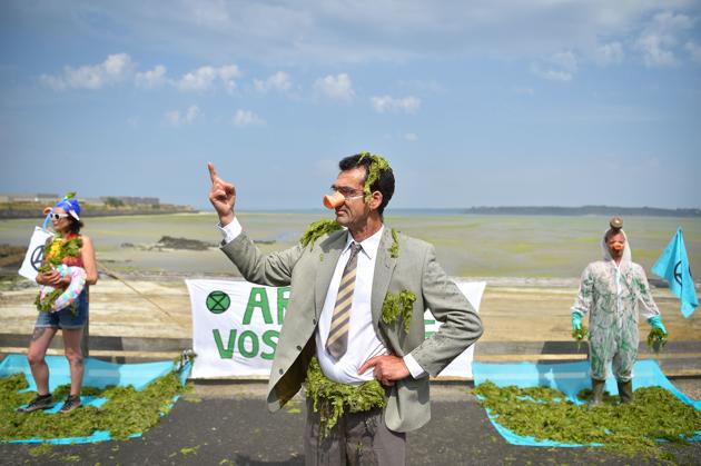 Activists protest against toxic seaweeds, in front of the Vallais beach covered with toxic green algae, in Saint-Brieuc, northwestern France. Fifty years after their appearance, green algae still arouse anger and associations call for more restrictive measures. (Loic Venance / AFP) Activists protest against toxic seaweeds, in front of the Vallais beach covered with toxic green algae, in Saint-Brieuc, northwestern France. Fifty years after their appearance, green algae still arouse anger and associations call for more restrictive measures. (Loic Venance / AFP)