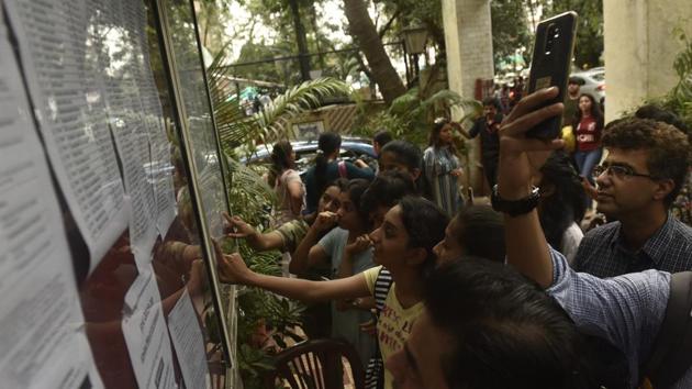 Students check the first merit list of FYJC, put up outside H R College at Churchgate in Mumbai on July 12.(HT FILE)