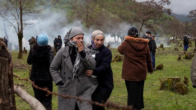 A woman covers her face during a rally held by residents of the Pankisi Gorge, who protest against the planned construction of a hydropower plant, near the village of Birkiani. (Ekaterina Anchevskaya / REUTERS)