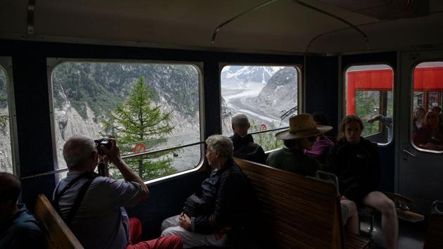 People sit and take pictures from the historical train to Chamonix and Montenvers on the Mer de Glace glacier. Among the changes that made these routes more complex and technically challenging are the appearance of bedrock, more fragile snow and ice and widening of crevasses. (Marco Bertorello / AFP) People sit and take pictures from the historical train to Chamonix and Montenvers on the Mer de Glace glacier. Among the changes that made these routes more complex and technically challenging are the appearance of bedrock, more fragile snow and ice and widening of crevasses. (Marco Bertorello / AFP)