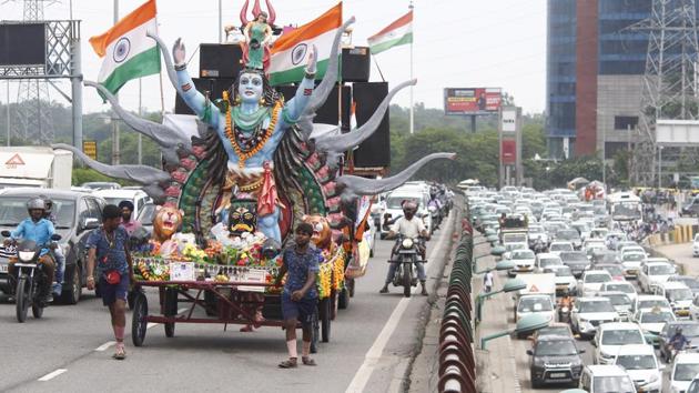 Kanwariyas pulling a Maha Kanwar decorated as a temple of Lord Shiva carrying holy water collected from the Ganga river at Delhi-Gurugram expressway, Sirhaul toll plaza, in Gurugram, on Monday, July 29, 2019.(Yogendra Kumar/HT PHOTO)