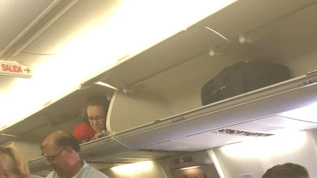 The image shows a flight attendant looking down at the passengers.(Twitter/@Disko_InVERNo)