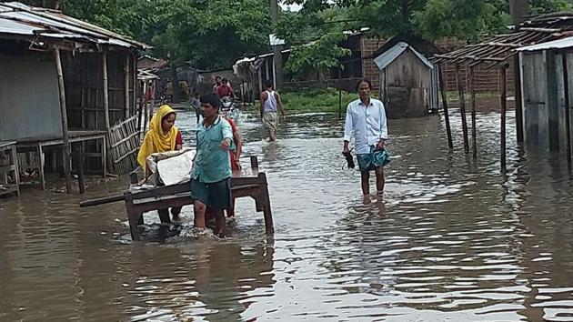 People struggle to move on a street flooded with water in Bihar. (HT Photo)