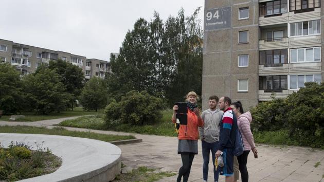A tour guide shows a group of tourists where the series ‘’ Chernobyl ‘’ was filmed in Vilnius, Lithuania. Tourists who come to this Baltic coastal country of 3 million to see the HBO filming locations first visit the KGB museum in downtown Vilnius where interrogation scenes were shot. They are taken to a Soviet-era district of gray condos built in the mid-1980s that look somewhat like Pripyat, a nuclear city that served the Chernobyl plant. (Mindaugas Kulbis / AP) 