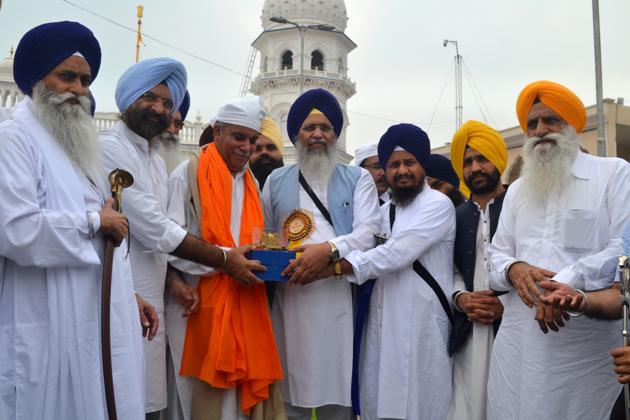 (LtoR) Akal Takht acting jathedar Giani Harpreet Singh, DSGMC president Manjinder Singh Sirsa and SGPC chief Gobind Singh Longowal presenting a Quran translated into Gurmukhi to the Evacuee Trust Property Board chairman Amir Ahmed at Nankana Sahib on Wednesday, July 31, 2019.(HT Photo)