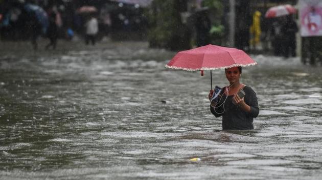 A girl walk along a flooded street after heavy rain showers Gandhi Market, Sion in Mumbai(HT FILE)
