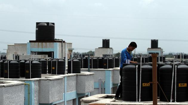 A file photo of water storage tanks on the top of buildings in Gurugram. Residents of sectors 81 to 98 might get supply of treated canal water by the end of September 2019.(Hindustan Times)