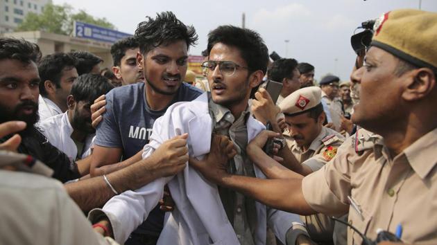Indian doctors scuffle with police during a protest against the National Medical Commission (NMC) Bill outside All India Medical Science in New Delhi on Thursday. The NMC bill seeks to replace the Medical Council of India. (Photo: AP)