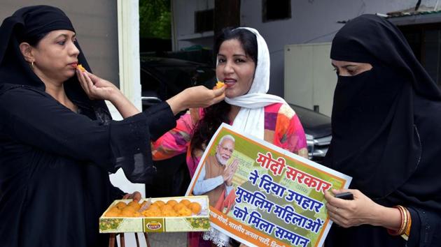 Muslim women offer sweets to each other as they celebrate the passage of triple talaq bill at Delhi BJP Office in New Delhi .(ANI)