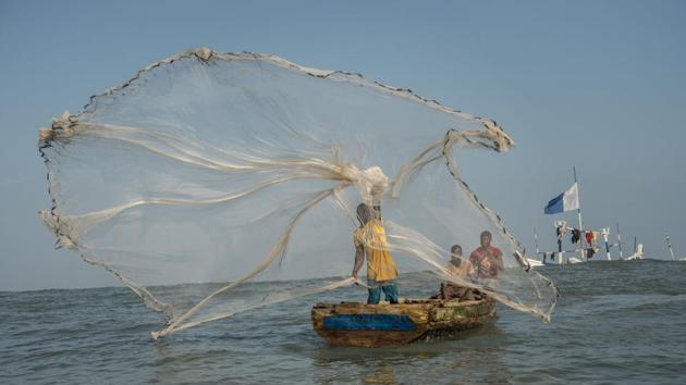 A fisherman casts his net in the waters of the Gulf of Guinea, outside Jamestown, the oldest fishing community in Accra, Ghana. The fishing sector is crucially important to the West African nation. It provides support for more than two million people, up to 10% of the population, and the produce it generates accounts for about 60% of the protein in the diet of Ghanaians. (Natalija Gormalova / AFP)