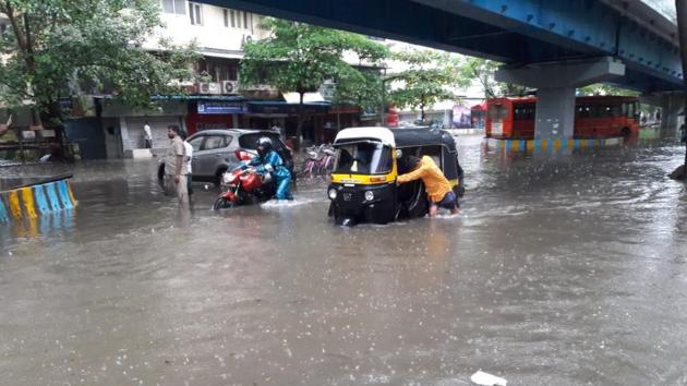 Man pulls through his auto rickshaw through waterlogged roads in Mumbai. (praful gangurde/HT Photo ) Man pulls through his auto rickshaw through waterlogged roads in Mumbai. (praful gangurde/HT Photo )