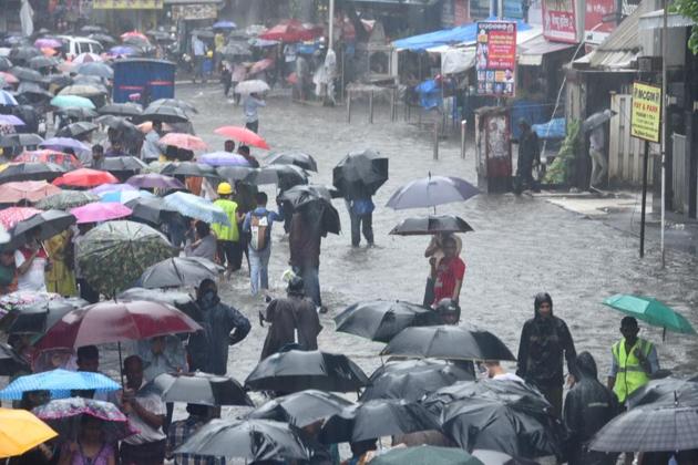 People stuck outside Mulund railway station due to heavy rains. (Satish Bate/HT Photo ) People stuck outside Mulund railway station due to heavy rains. (Satish Bate/HT Photo )
