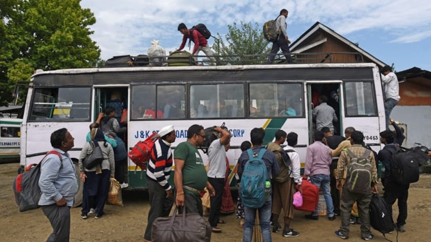 Tourists walk towards their bus in Srinagar to leave Kashmir valley after a government advisory about a terror threat.(Waseem Andrabi/HT PHOTO)