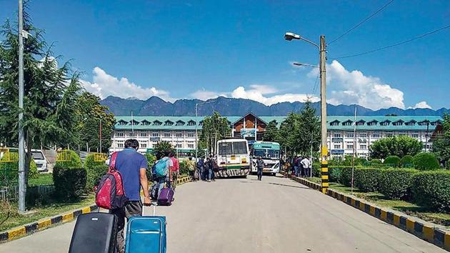 Students leave the NIT Srinagar campus on Saturday, a day after the government issued a security advisory asking tourists and pilgrims to curtail their stay in Kashmir.(PTI photo)