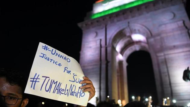 Indian social activists uses their mobile light as they take part in a solidarity rally in front of India Gate monument for the Unnao rape victim in New Delhi on July 29, 2019. - An Indian teenager who accused a senior politician of rape is fighting for her life after being critically injured in a crash on July 28, 2019 that killed two relatives, raising suspicions of foul play. (Photo by SAJJAD HUSSAIN / AFP)(AFP)